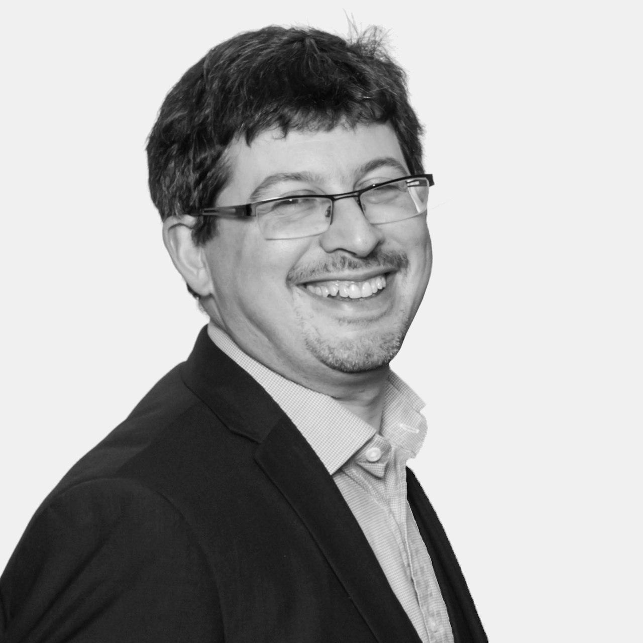 A modern living room featuring a grey sofa, wooden coffee table, and large window with natural light.